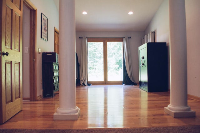 interior space featuring hardwood / wood-style flooring and ornate columns