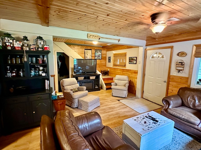 living room featuring light wood-type flooring, ceiling fan, wooden walls, and wooden ceiling