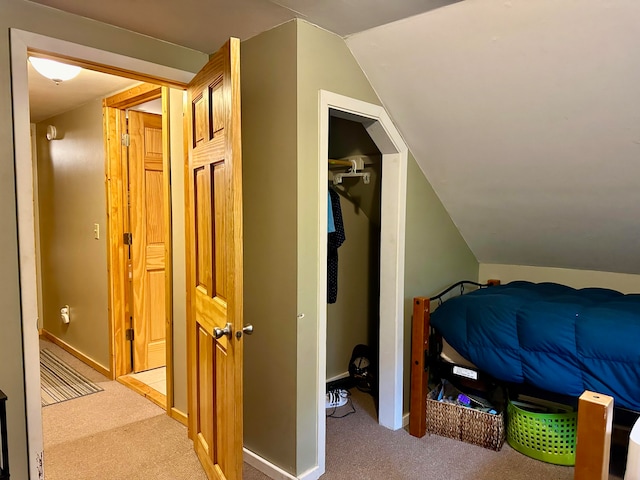 carpeted bedroom featuring vaulted ceiling and a closet