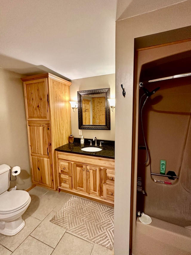 bathroom with tile patterned flooring, vanity, toilet, and walk in shower