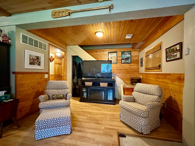 sitting room featuring wooden ceiling, hardwood / wood-style flooring, and wood walls