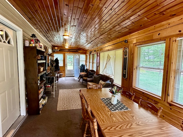 dining space with wood ceiling, carpet flooring, and wooden walls