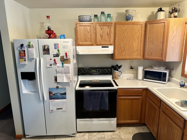 kitchen with white appliances, light countertops, a sink, and under cabinet range hood