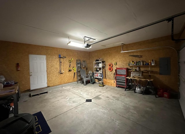 garage featuring a workshop area, electric panel, and a garage door opener