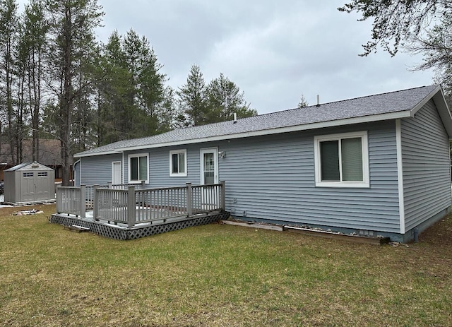 rear view of house featuring a yard, a shed, a wooden deck, and an outdoor structure