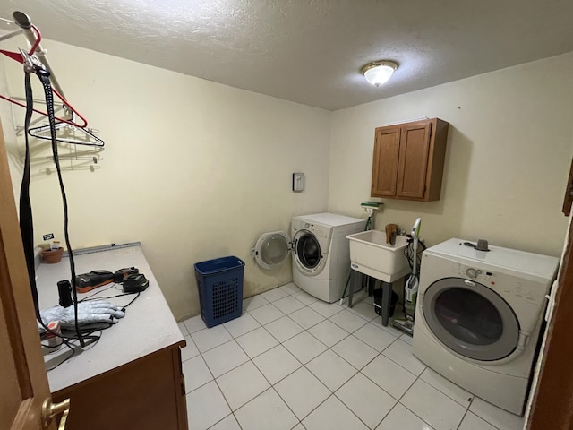 washroom with washer and clothes dryer, cabinets, light tile patterned floors, and sink