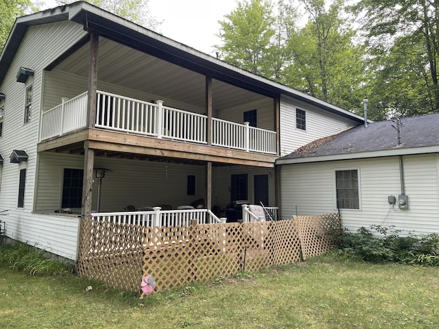 rear view of house with a lawn and a wooden deck