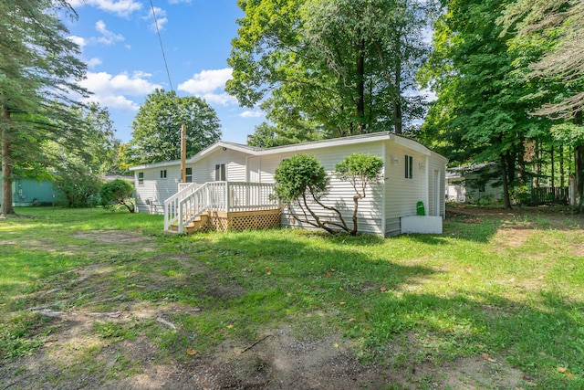 rear view of house with a yard and a deck