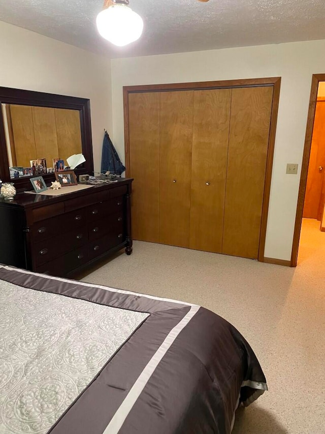 bedroom with a textured ceiling and a closet