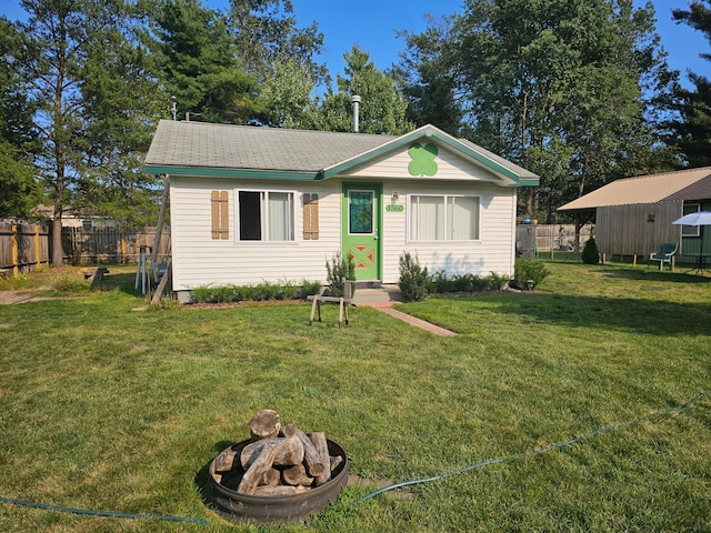 ranch-style home with a front yard and a fire pit