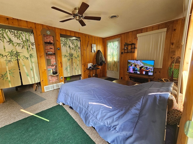 bedroom featuring carpet flooring, ceiling fan, and wooden walls