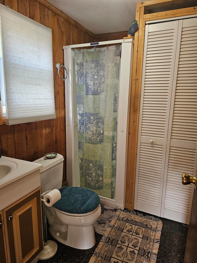 bathroom featuring wooden walls, toilet, a shower with curtain, vanity, and a textured ceiling