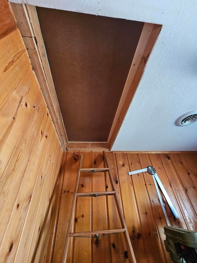 interior details featuring wood walls and a textured ceiling