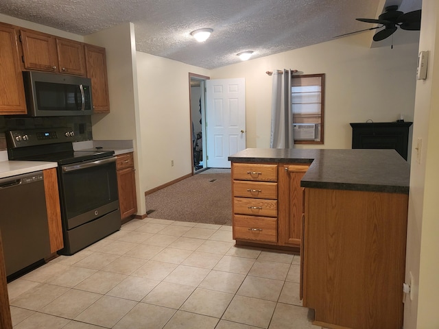 kitchen featuring ceiling fan, stainless steel appliances, cooling unit, a textured ceiling, and light tile patterned flooring