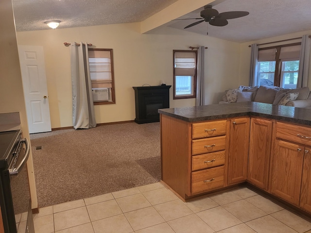 kitchen with stainless steel electric range, ceiling fan, a textured ceiling, light colored carpet, and kitchen peninsula