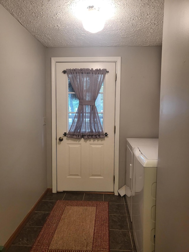 interior space with washer and dryer, dark tile patterned floors, and a textured ceiling