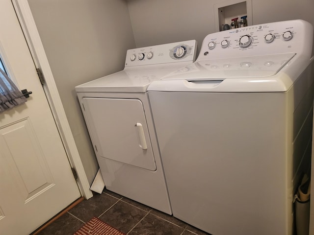 laundry area with washing machine and clothes dryer and dark tile patterned floors