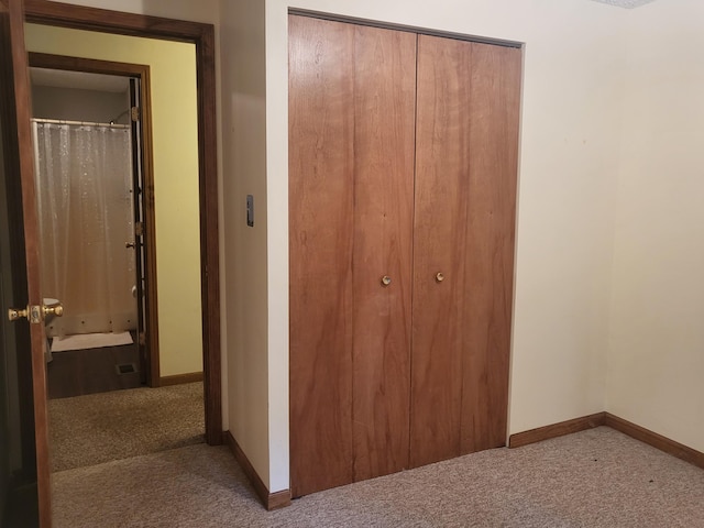 unfurnished bedroom featuring carpet flooring, connected bathroom, and a closet