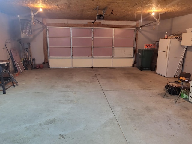 garage featuring a garage door opener and white refrigerator