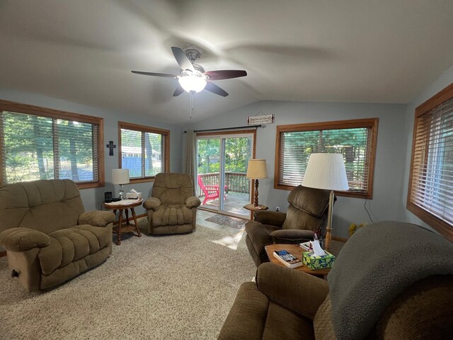 carpeted living room with ceiling fan and vaulted ceiling