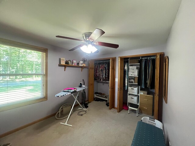 interior space with ceiling fan and light carpet