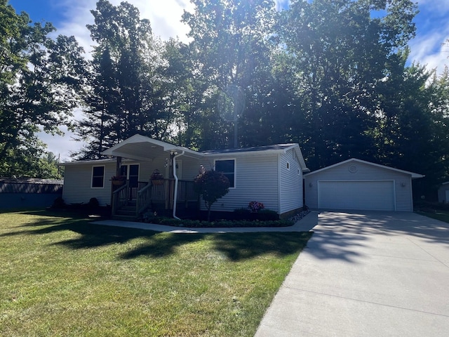 view of front of house featuring a garage, a front yard, and an outbuilding