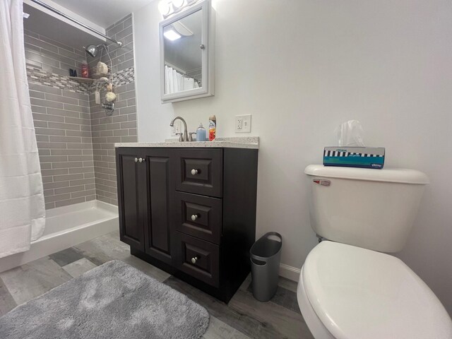 bathroom with a shower with shower curtain, toilet, hardwood / wood-style flooring, and vanity