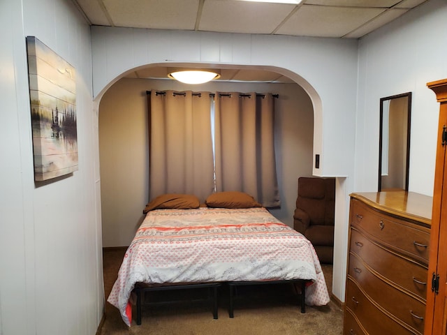 bedroom with a drop ceiling and carpet floors