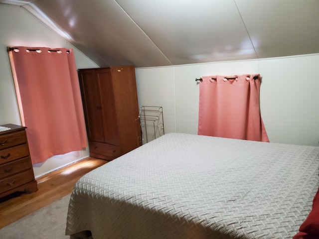 bedroom with lofted ceiling and wood-type flooring