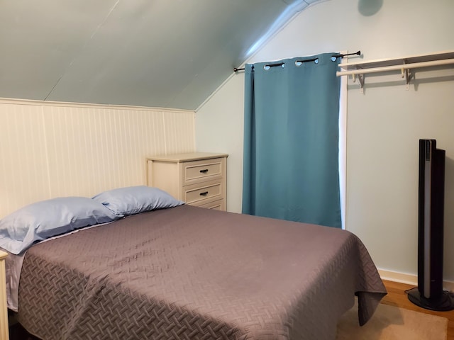 bedroom featuring hardwood / wood-style floors and vaulted ceiling