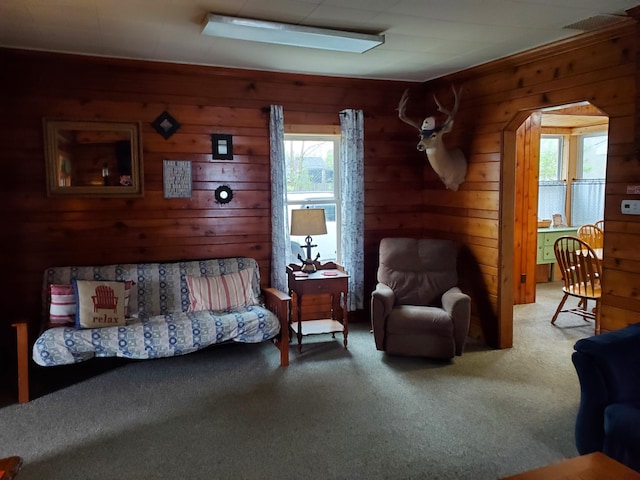 carpeted bedroom with multiple windows and wooden walls