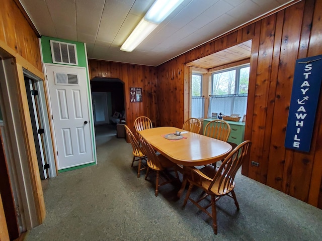 dining room featuring wood walls