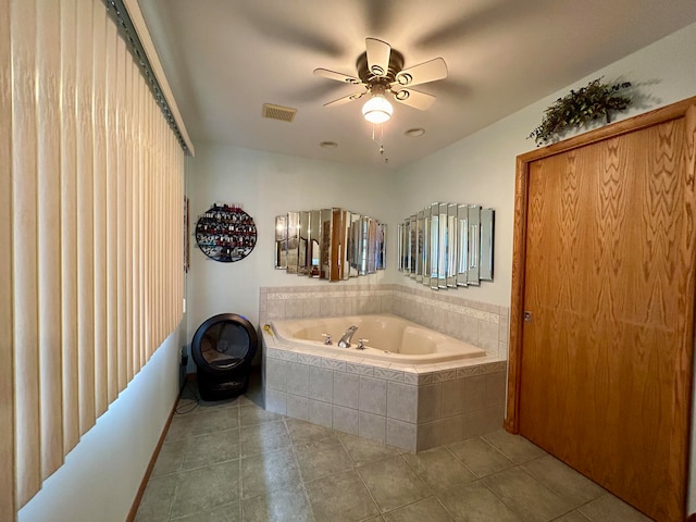 bathroom with tile patterned flooring, ceiling fan, and tiled bath