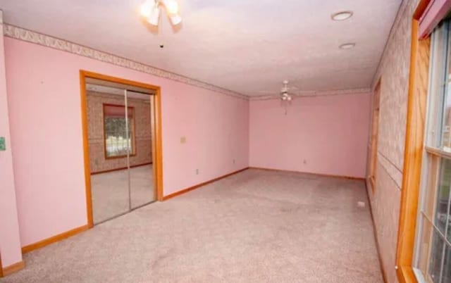 carpeted spare room with ceiling fan