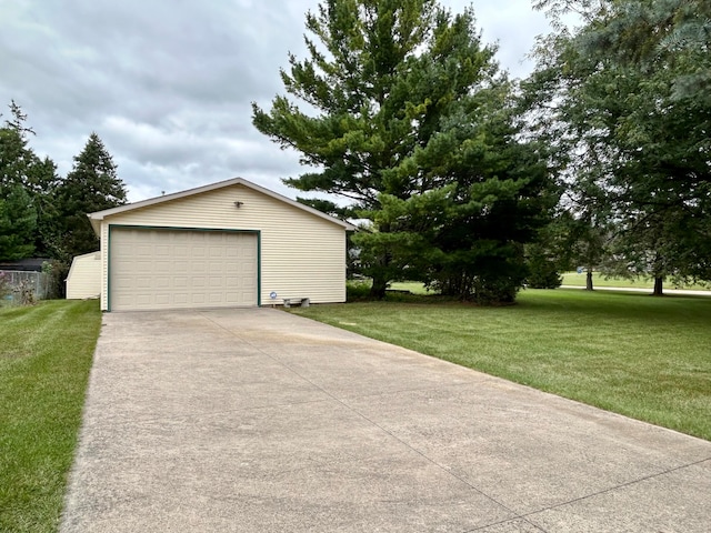 exterior space with a lawn, a garage, and an outbuilding