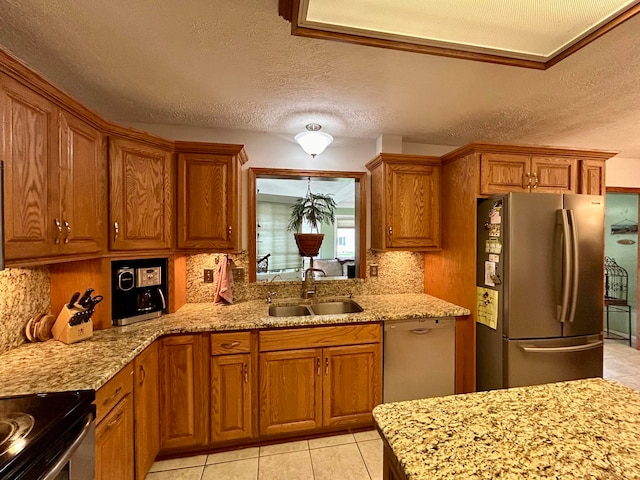 kitchen featuring a textured ceiling, light tile patterned floors, sink, light stone countertops, and appliances with stainless steel finishes