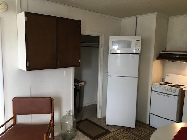 kitchen with white appliances, dark brown cabinets, dark carpet, and exhaust hood