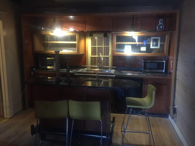 kitchen with a kitchen breakfast bar, hardwood / wood-style floors, and sink