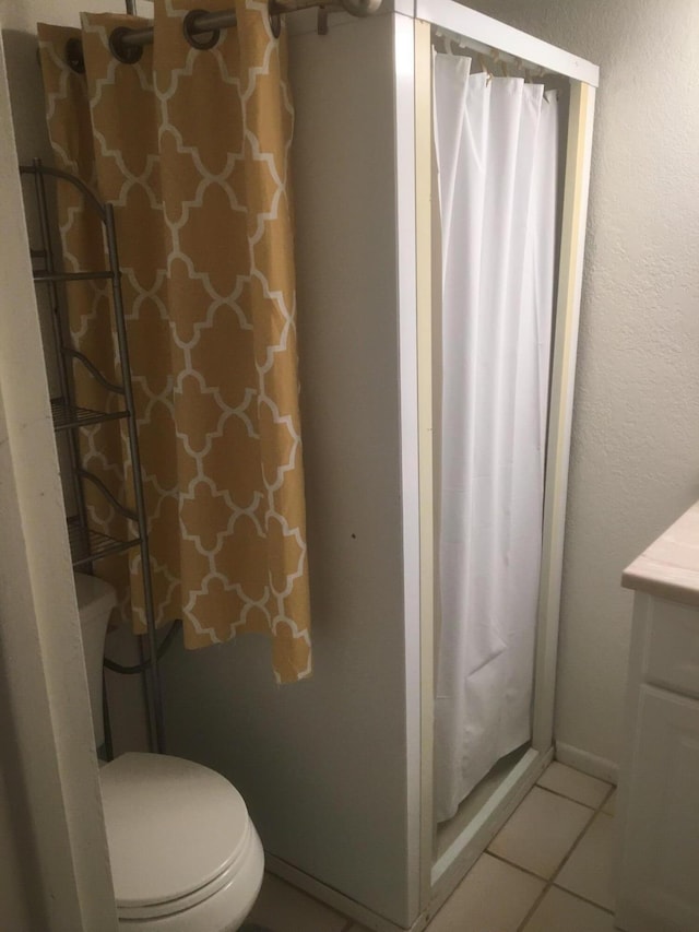 bathroom with tile patterned flooring, toilet, vanity, and curtained shower