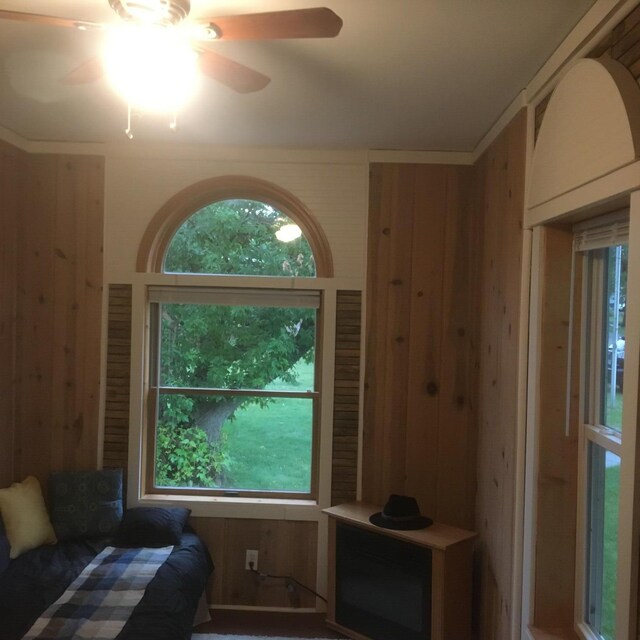 bedroom with wood walls and ceiling fan