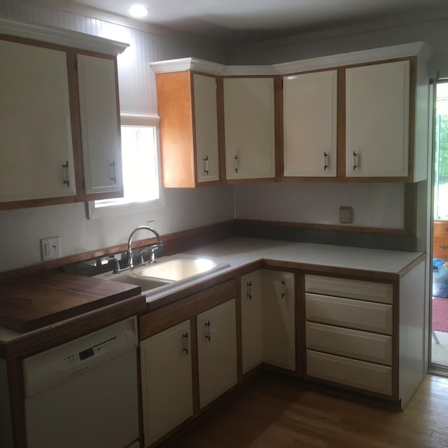 kitchen featuring hardwood / wood-style floors, white cabinetry, dishwasher, and sink