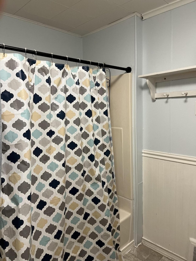 bathroom with shower / bath combo and ornamental molding