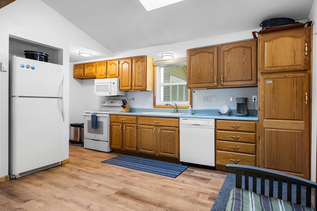 kitchen with sink, light wood-type flooring, vaulted ceiling, and white appliances