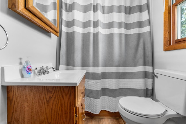 bathroom featuring wood-type flooring, vanity, and toilet