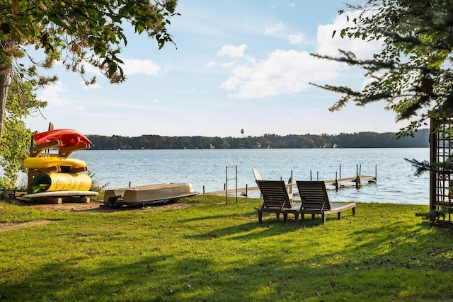 dock area with a lawn and a water view