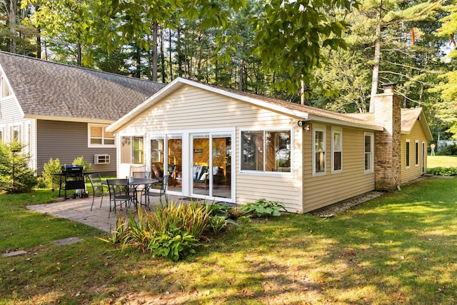 back of property with a patio and a yard