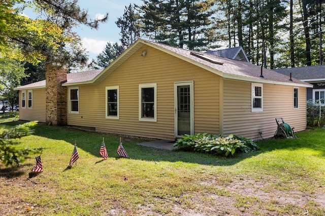 rear view of property with a yard