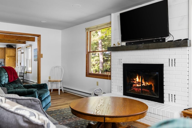 living room featuring a baseboard heating unit, hardwood / wood-style flooring, and a fireplace