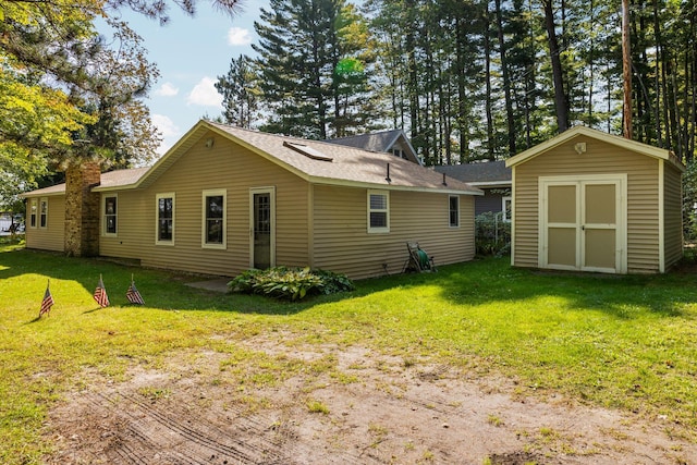 back of property with a lawn and a storage unit