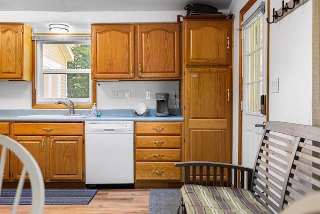 kitchen featuring light wood-type flooring, sink, and white dishwasher